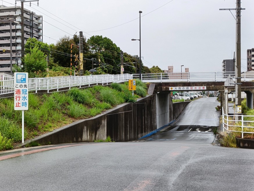 周囲より低い位置を通るアンダーパスと冠水注意を呼びかける道路標識