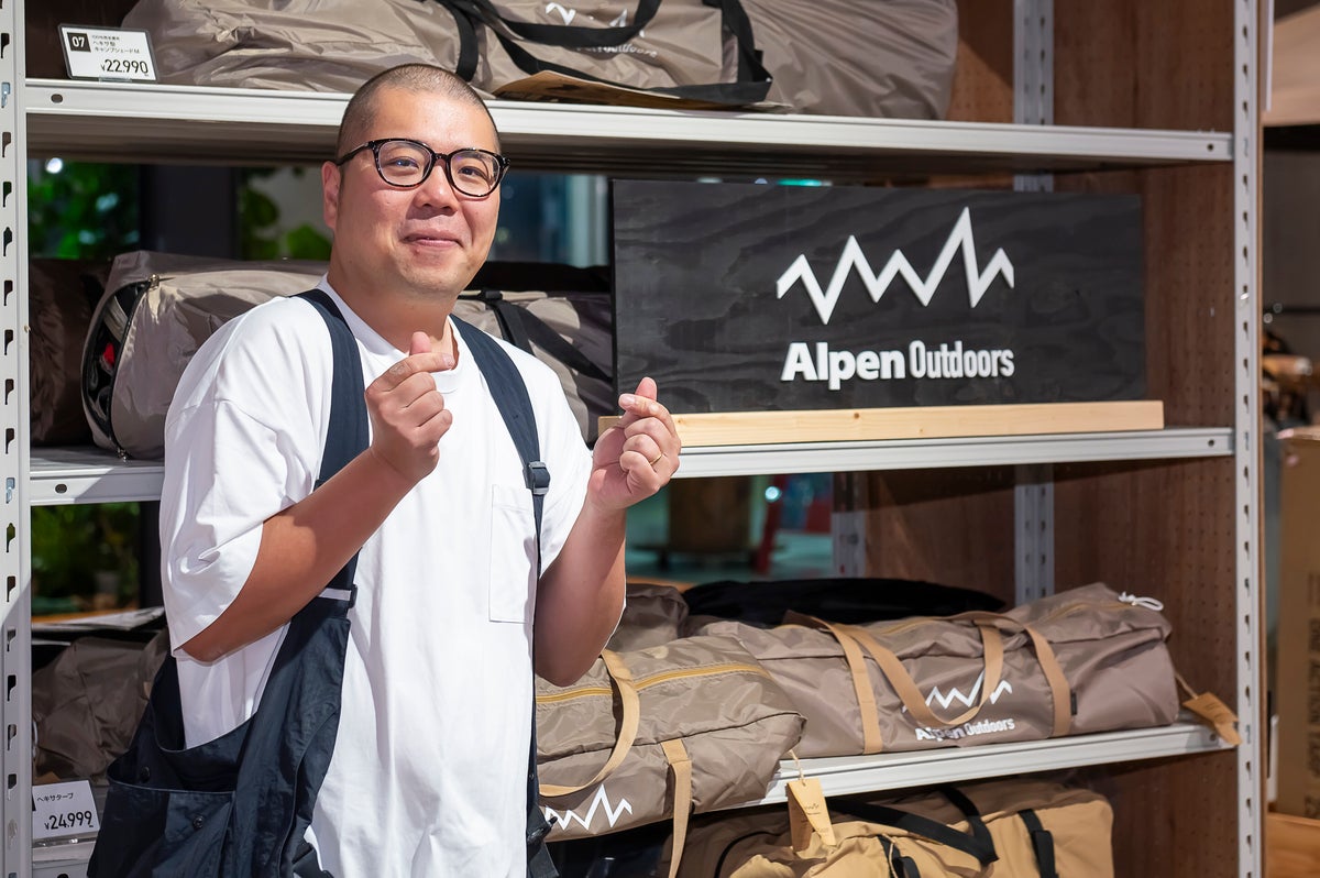 アウトドアショップ売り場でポーズを取る男性スタッフ