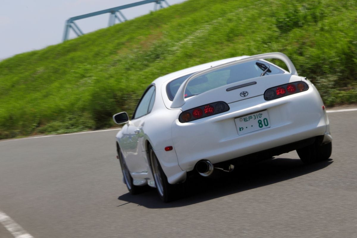 道路を走り去る白いスープラの後ろ姿