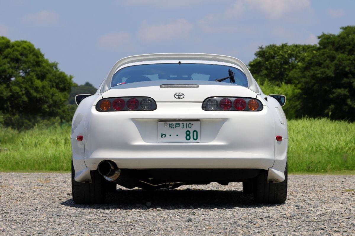 砂利の駐車場に停車するA80スープラ