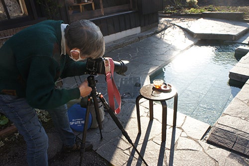 湧き水の前でかんざらしを撮影するカメラマン