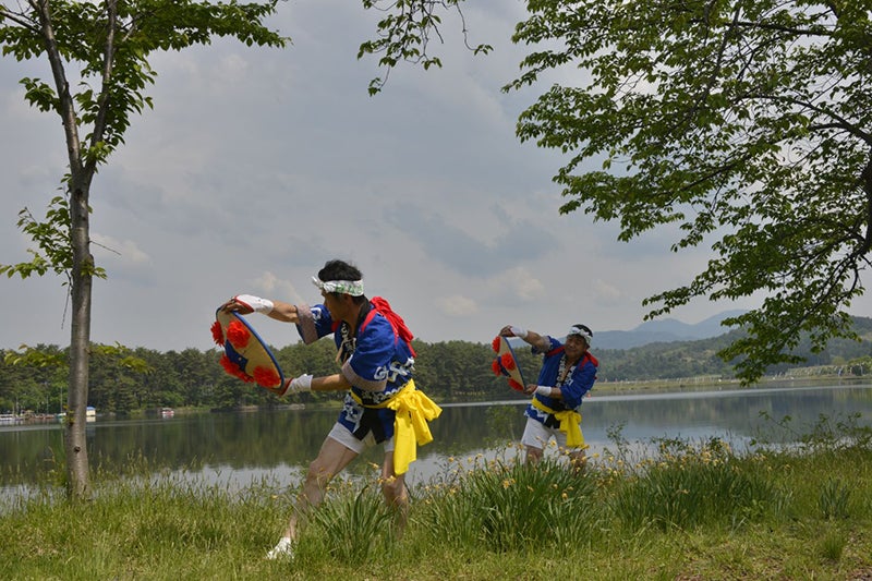 徳良湖畔で花笠踊りを踊る2人の男性
