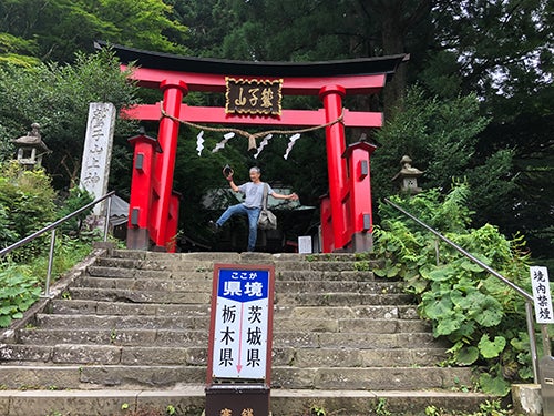 鷲子山上神社の県境でポーズを取るヤスクニさん