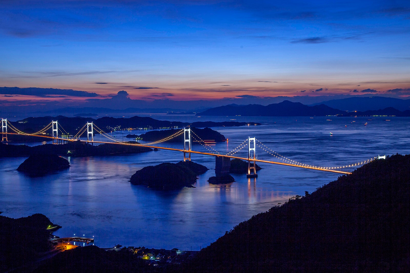 写真3 世界初の三連吊橋「来島海峡大橋」。時期により、週末の日没から夜間にかけてライトアップされる（撮影エリアは地図３を参照）