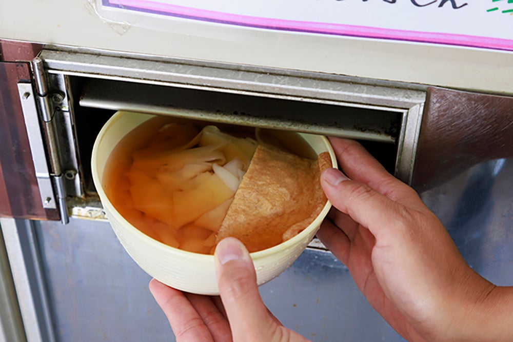 食品自販機から取り出すうどん