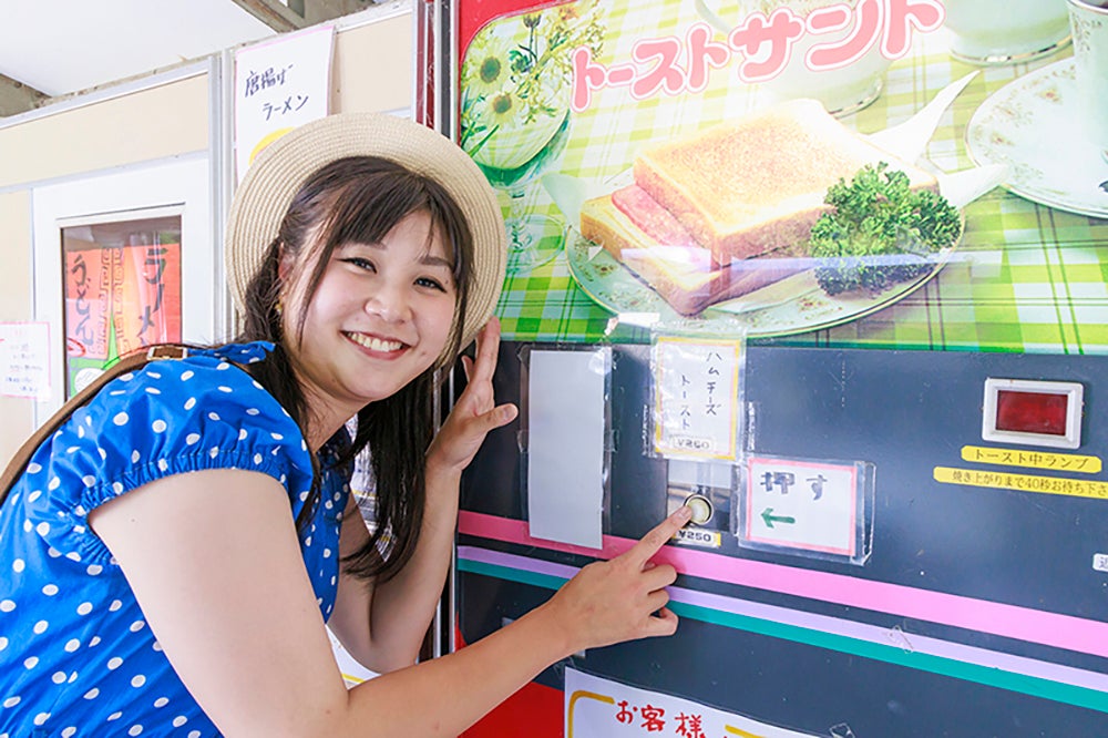 トーストの自販機のスイッチを押す小林さん