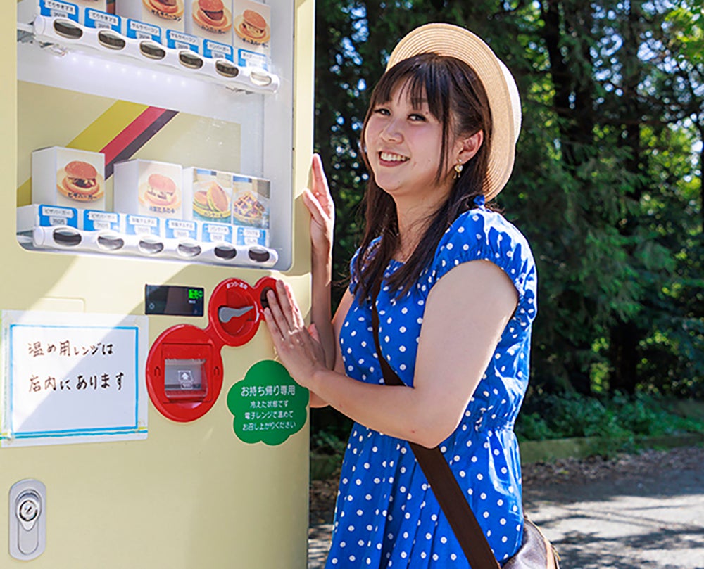 食品自販機の前に立つ小林さん