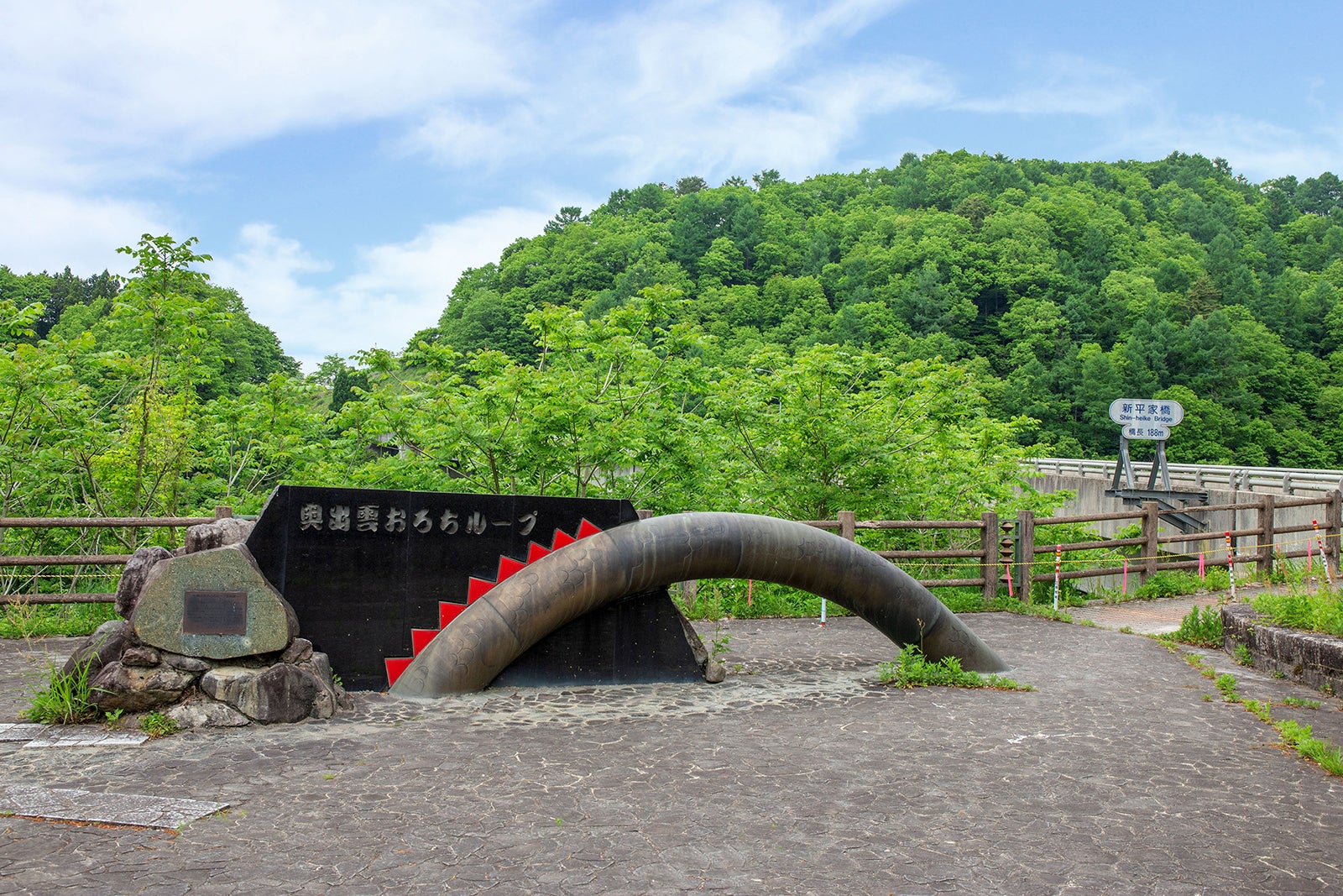 写真3 三井野大橋の赤色とループの湾曲した弧を表現した石碑は、奥出雲おろちループ展望台の新平家（しんへいけ）橋近くに設置されている（撮影エリアは地図3を参照）