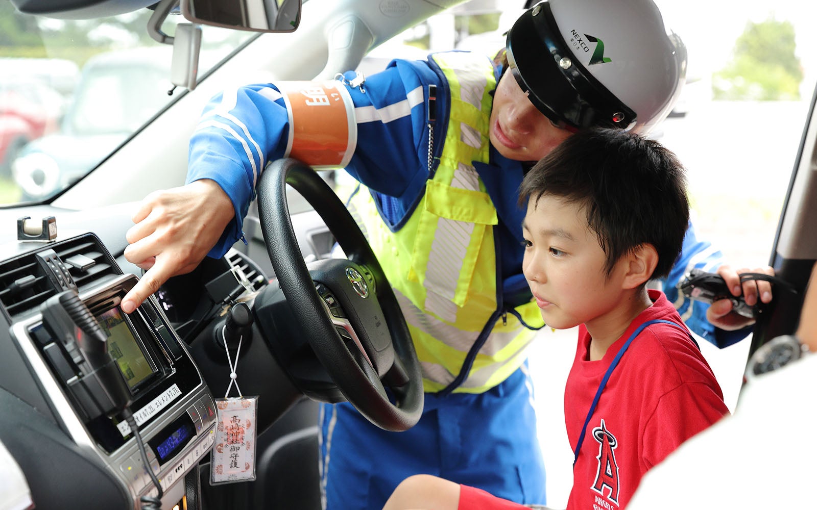 サイレンやマイクなど車内の設備を見学する子供