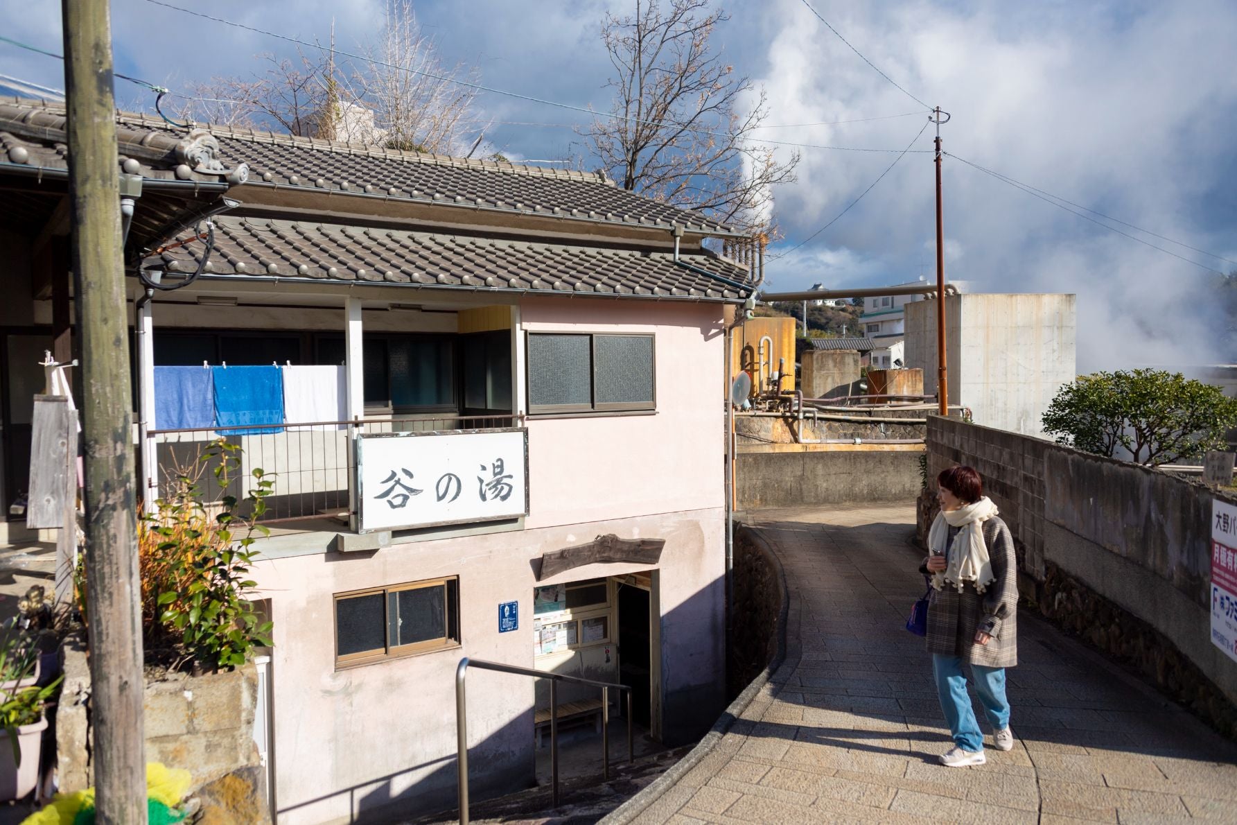 谷の湯の横を歩く人