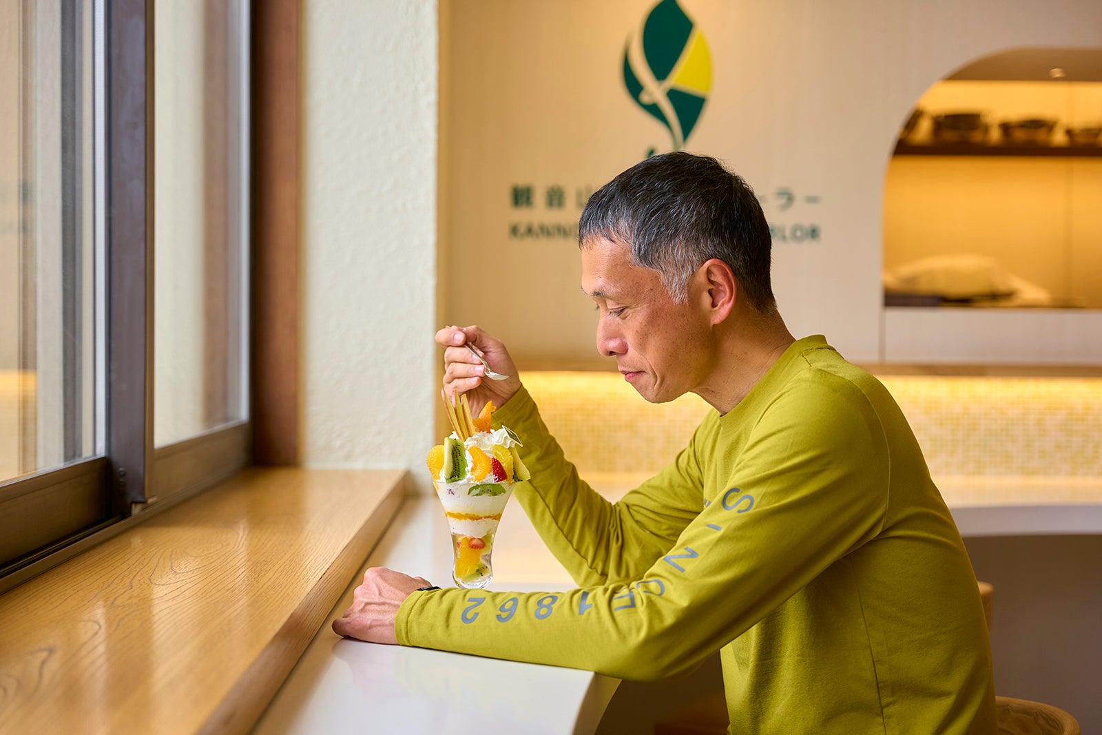 旬フルーツの農園パフェを食べる男性