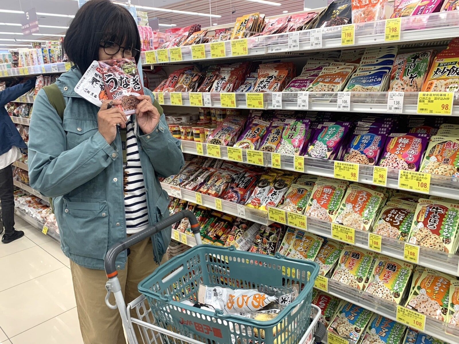 スーパーのふりかけコーナーで商品を手にする女性
