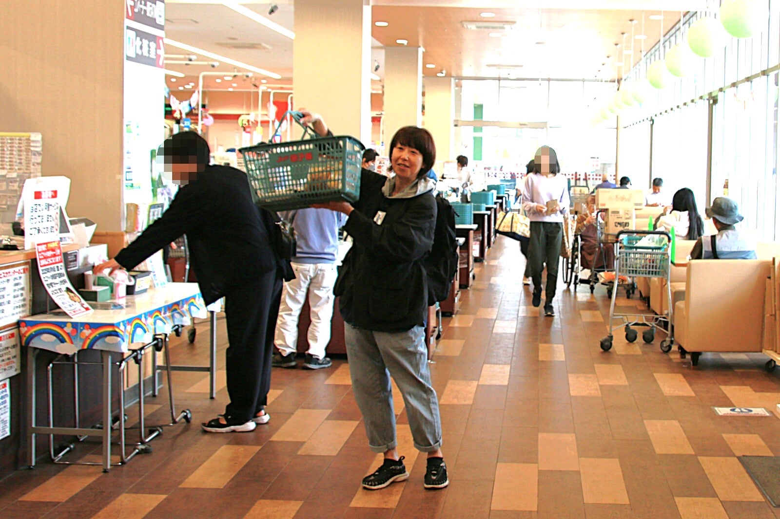 店内でスーパーのカゴを持ち上げてはしゃぐ女性