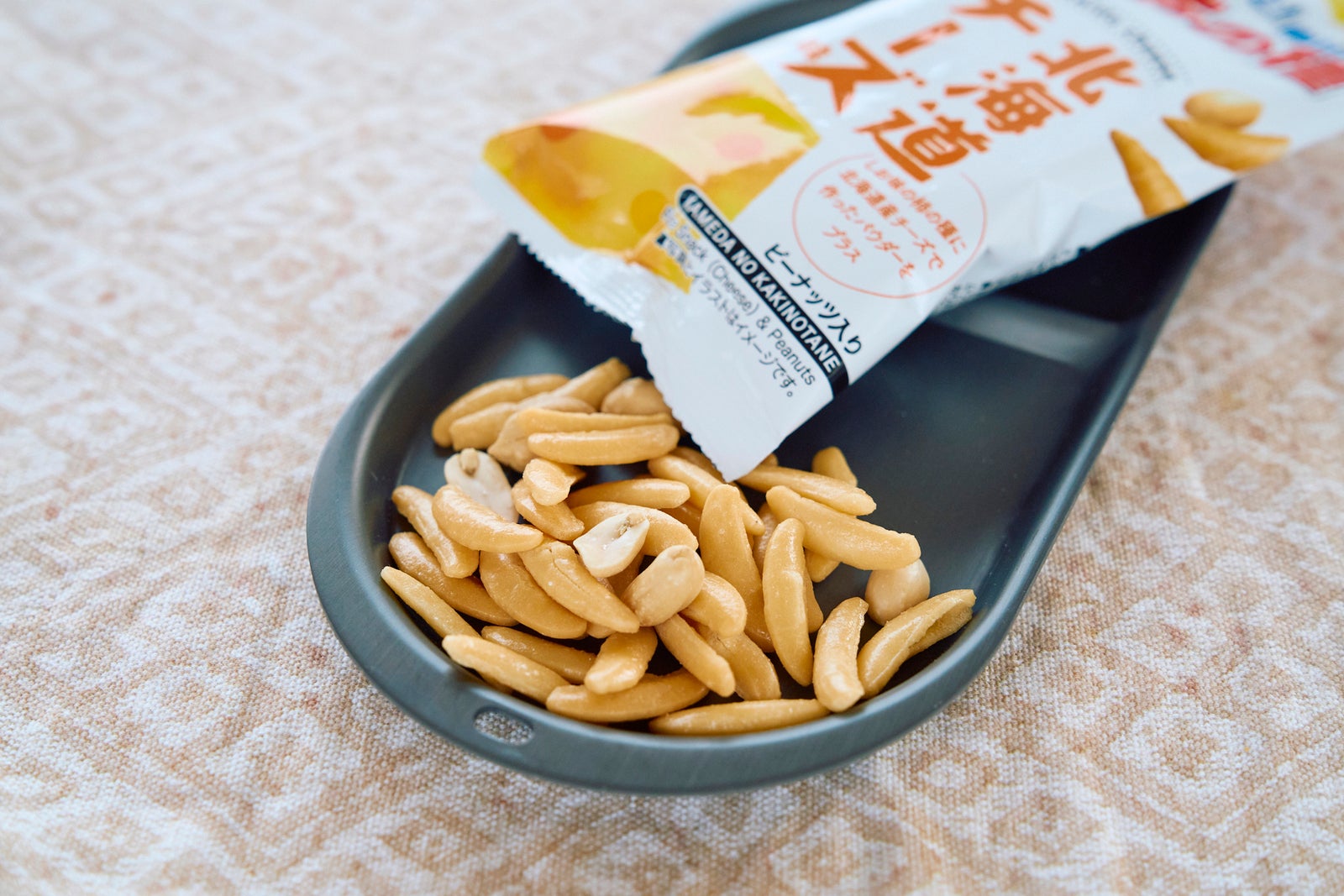 チーズ味の柿の種を袋から皿に出した画像
