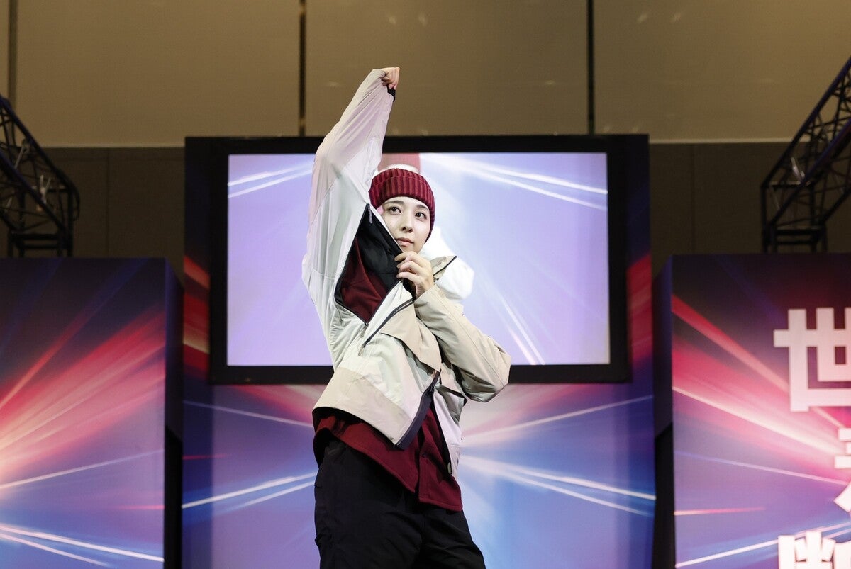 ウエアのフードをかぶりステージショーで歩く女性