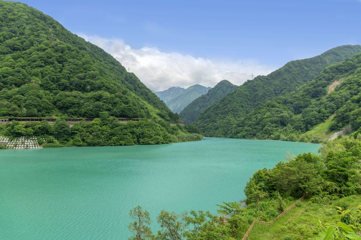 富山県のうなづき湖を尾の沼公園から望む絶景。コバルトブルーの湖面と立山連峰に囲まれた黒部峡谷の癒やしの風景
