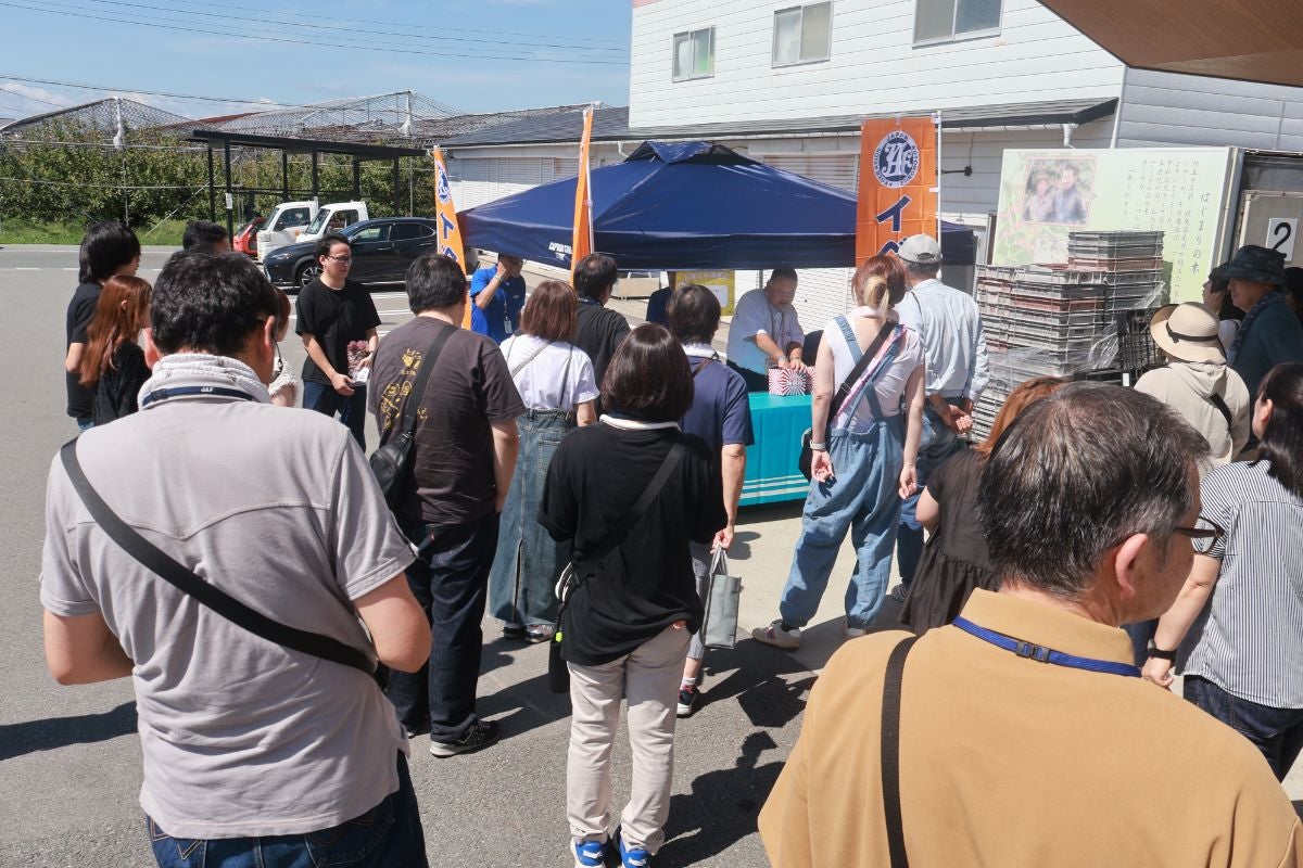 JAFフェスティバル東北の受付ブースに集まる参加者、王将果樹園でのぶどう食べ放題イベント開始前の様子