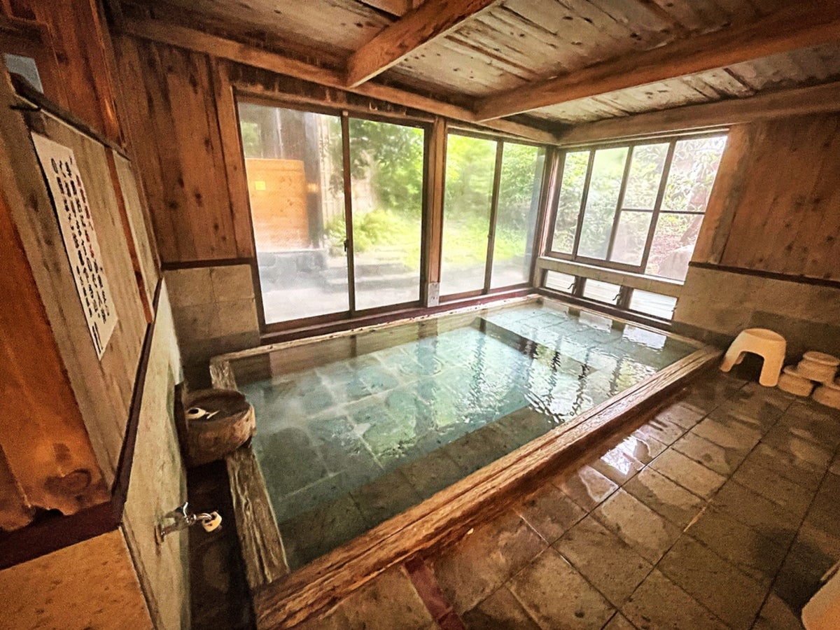木造の建物内の温泉の湯船