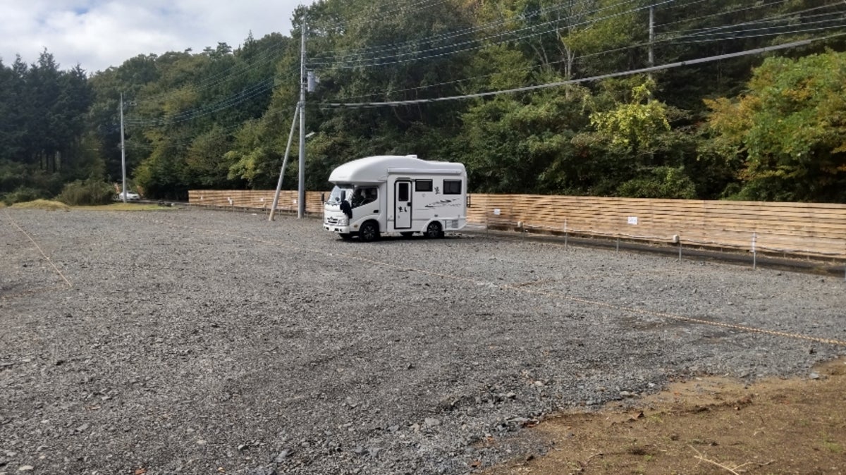 砂利の駐車場の奥に駐車するキャンピングカー