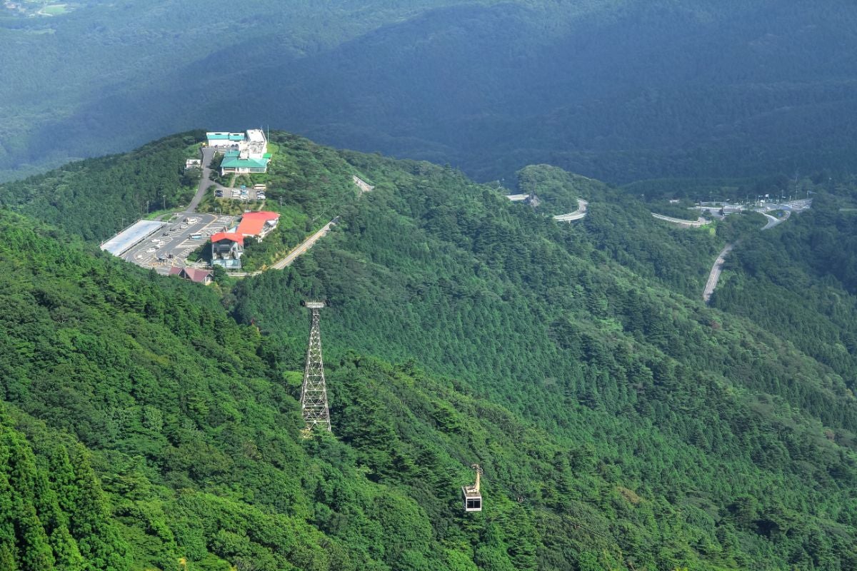 筑波山女体山からの眺望、緑に覆われた山並みとロープウェイ、山頂付近の施設が見える絶景パノラマ