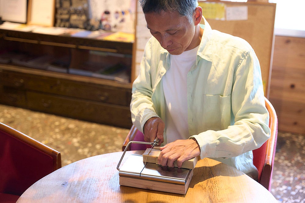 その日使う分の石鹸をカットする男性