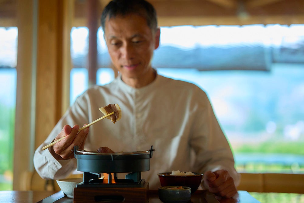 いのししすき焼き定食を食べる男性