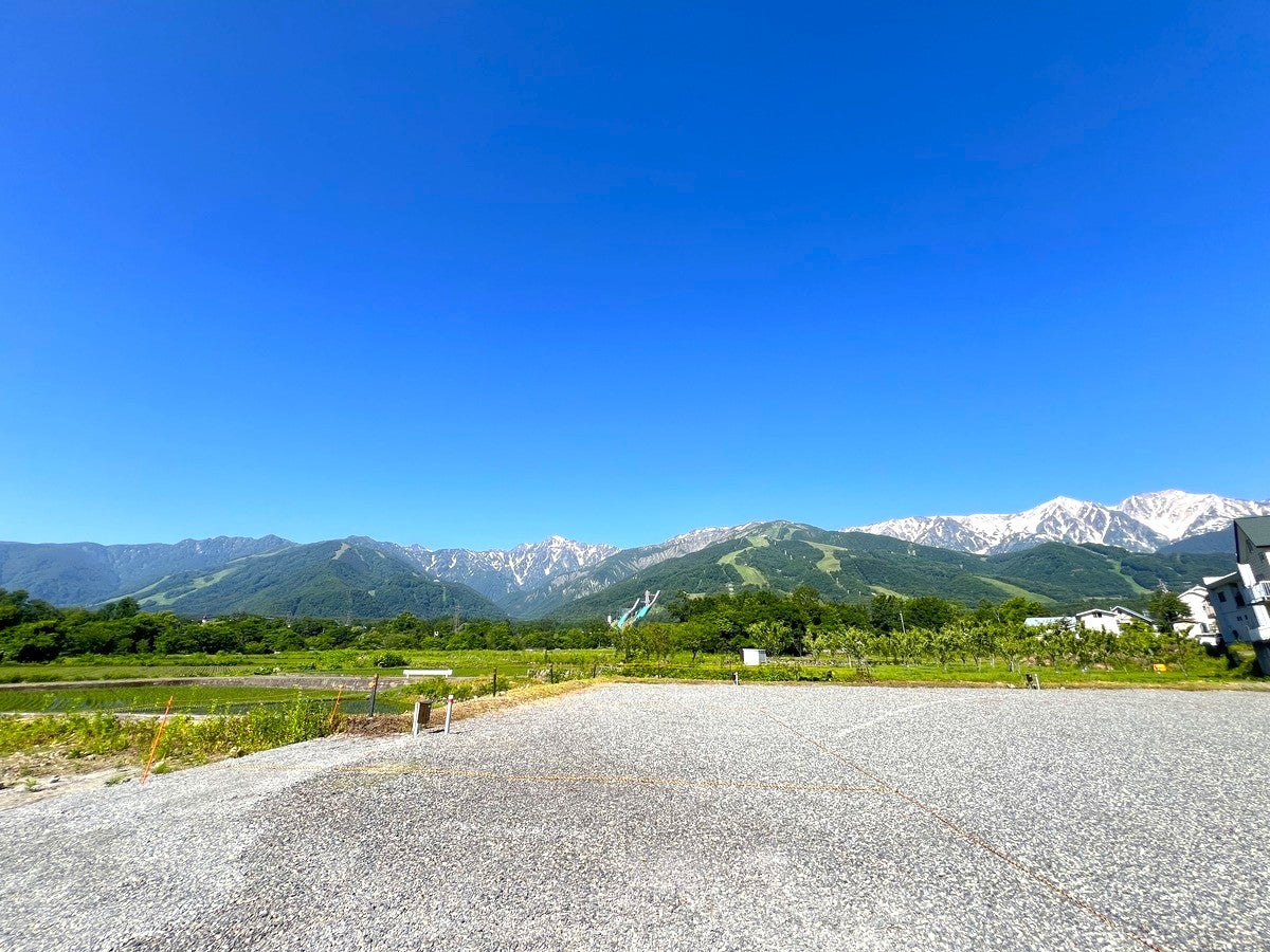 白馬の山々をバックにした広大な駐車場の写真