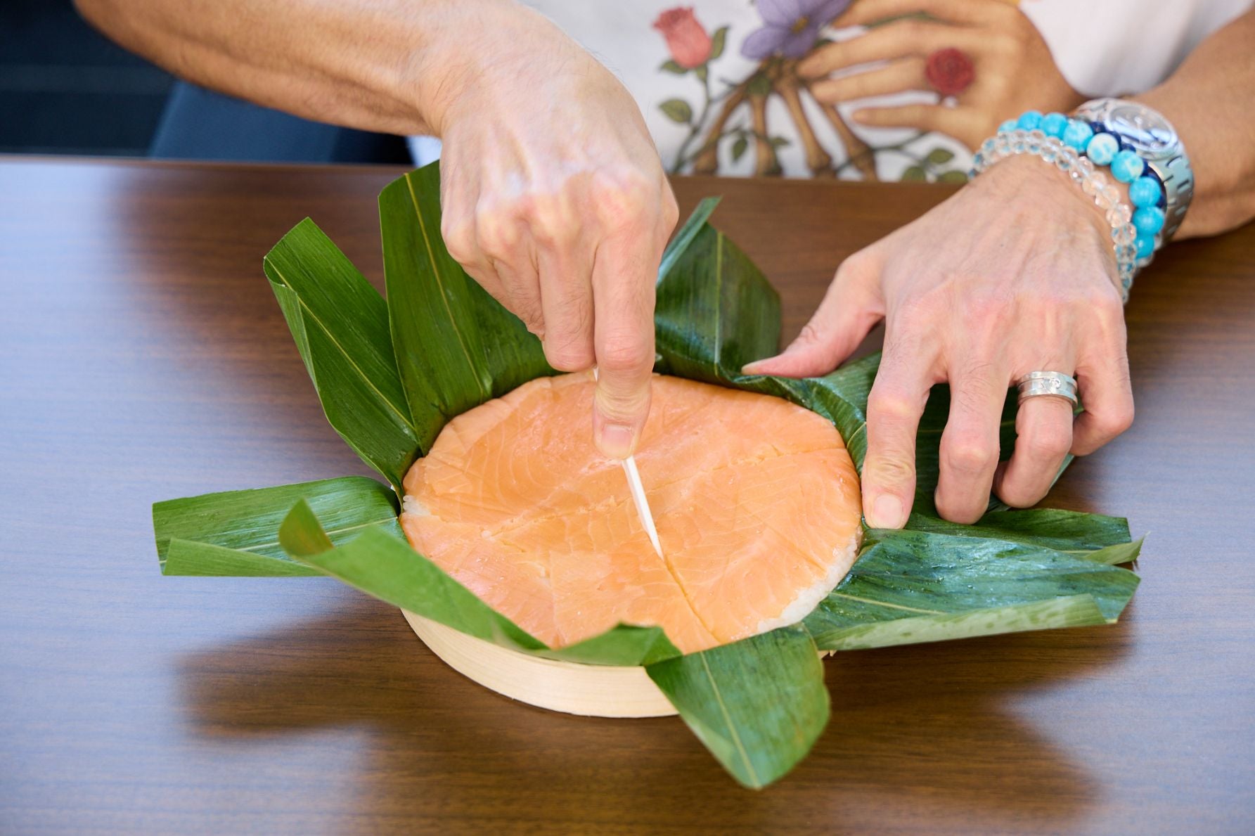 鱒の身の旨味と富山県産米のすし飯が特徴の、ますのすし一重。同梱のナイフでカットする様子