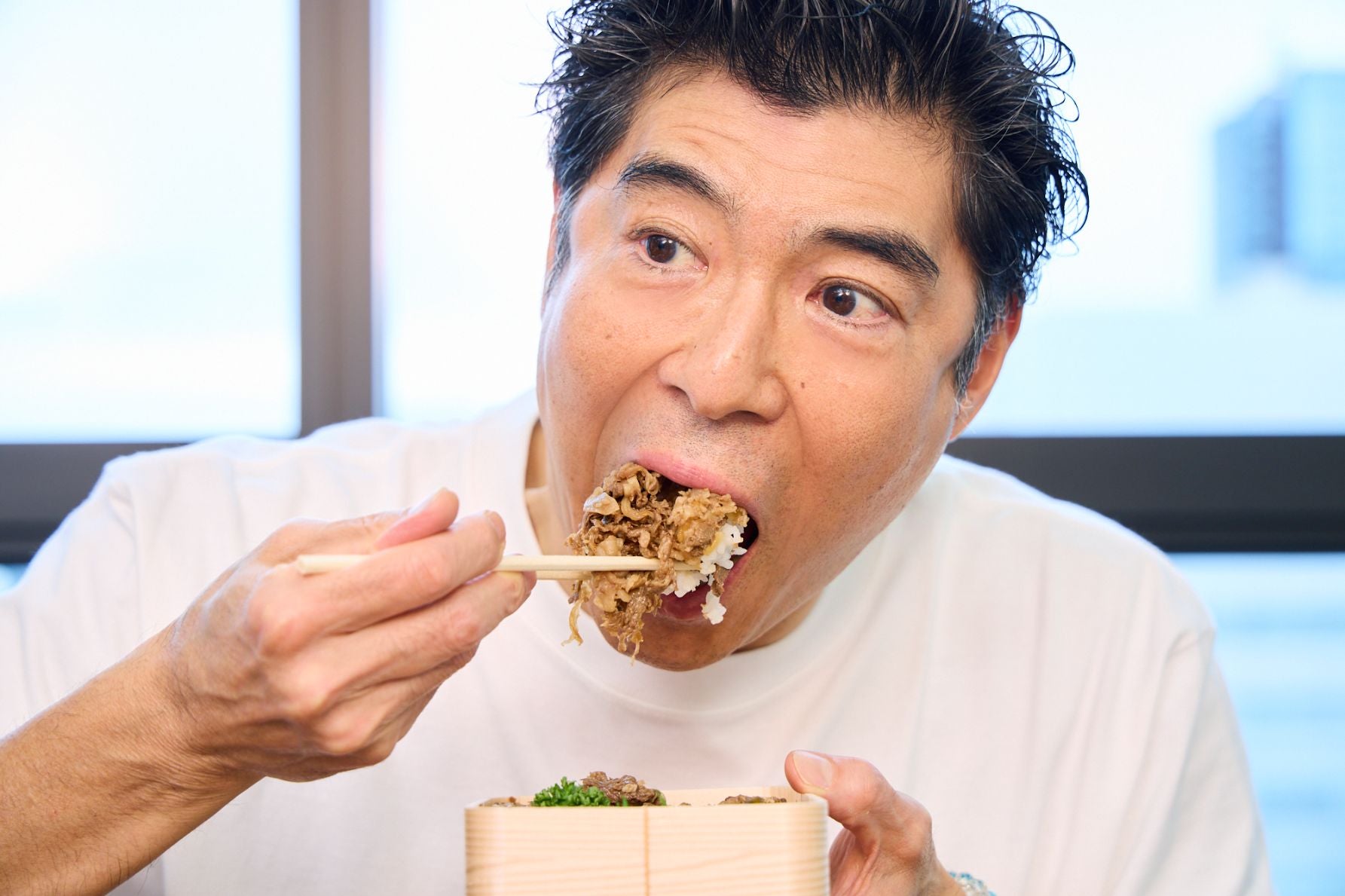 山形新幹線開業に合わせて開発された、老舗メーカー新杵屋の看板商品「牛肉どまん中」を食べる高嶋さん