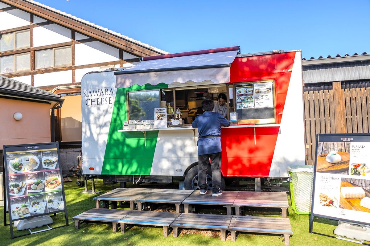チーズを販売するトレーラーハウス全景と客