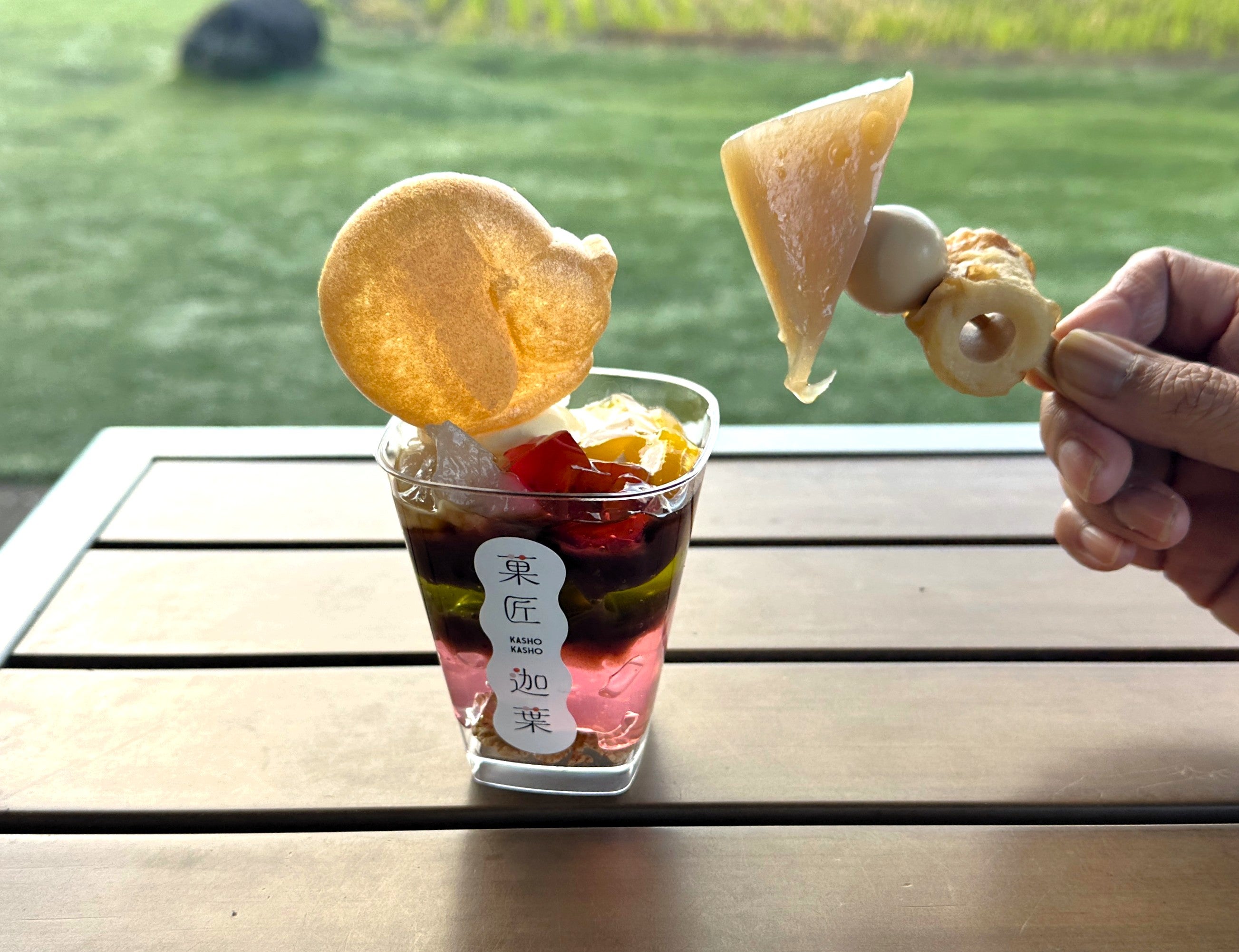 テーブルにのせたあんみつと手に持ったミニおでん