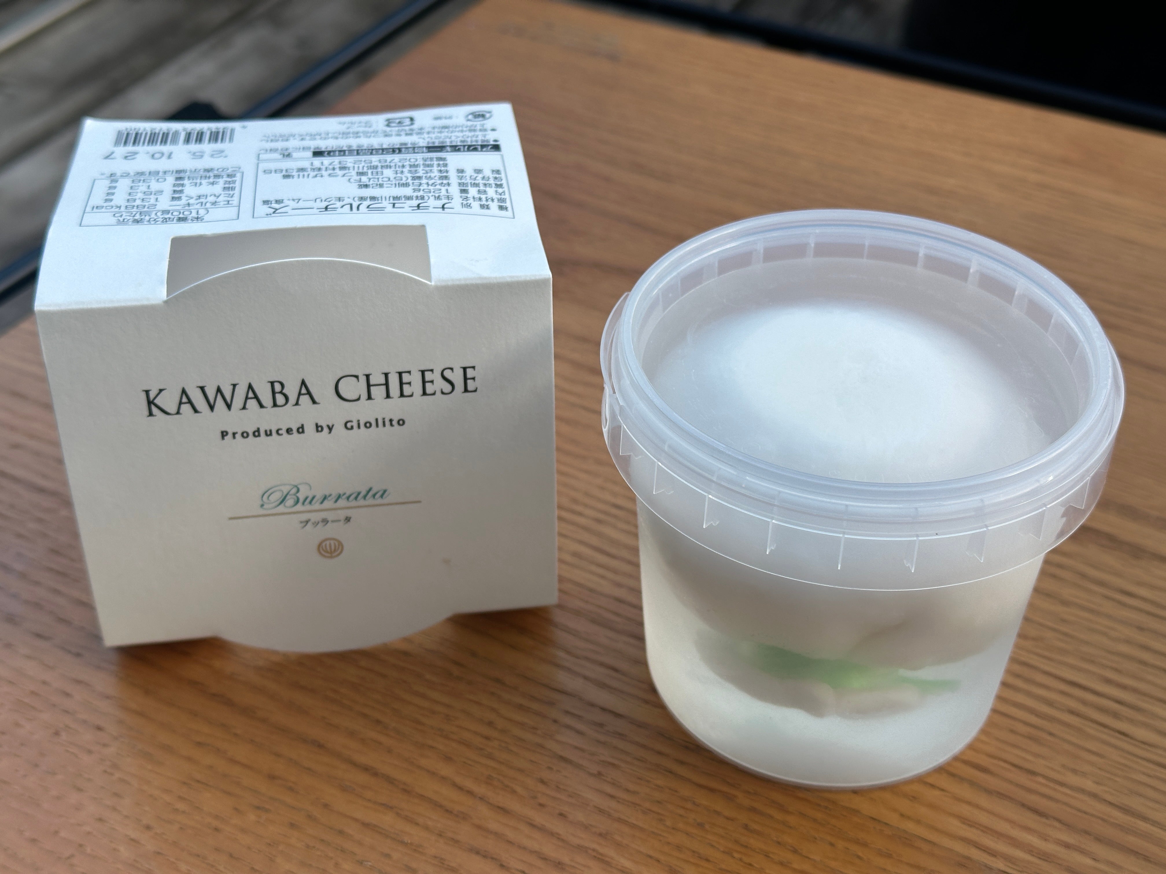 テーブルの上に置いたお土産用ブッラータチーズのパッケージと容器