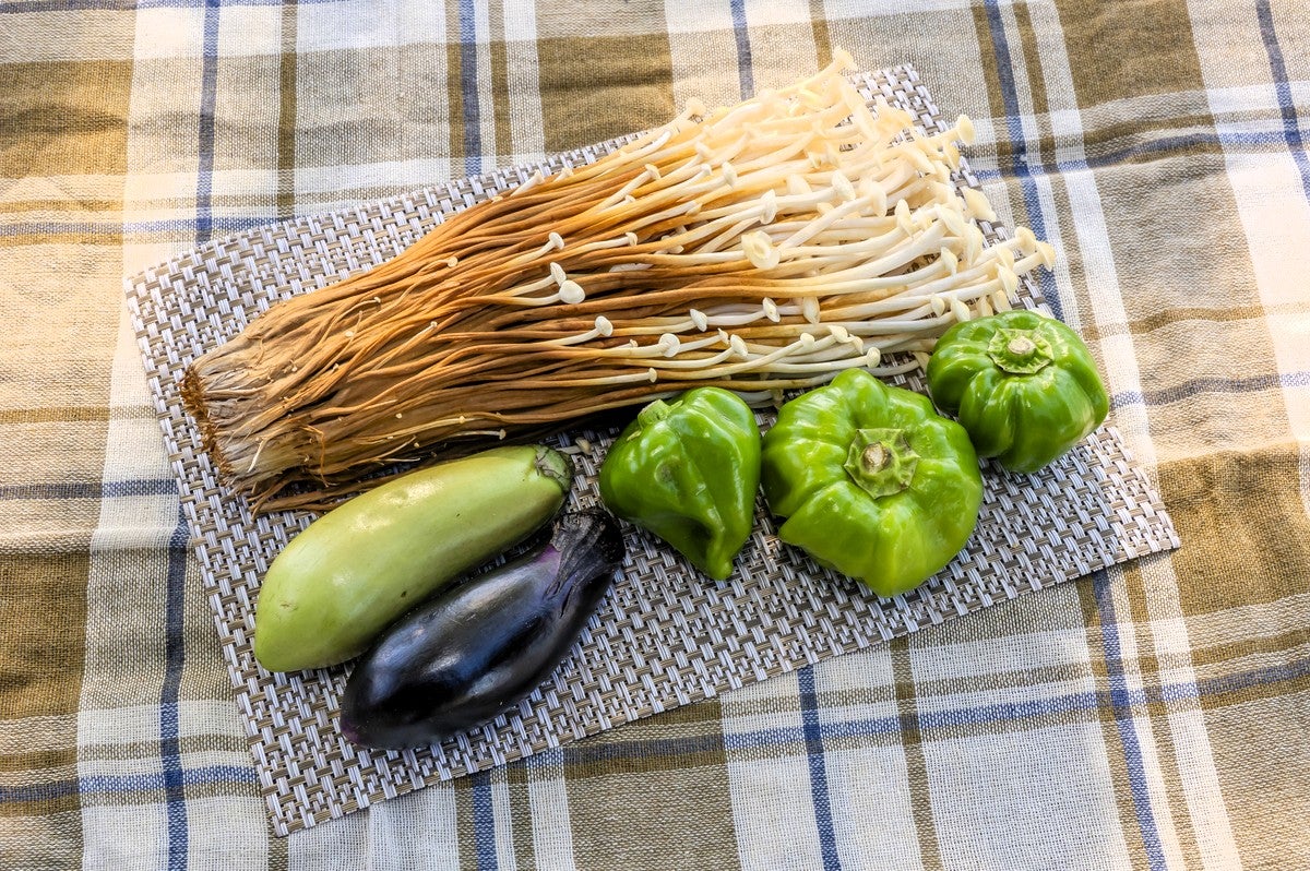 テーブルの上にのせた雪割茸、かぐら辛子、なす