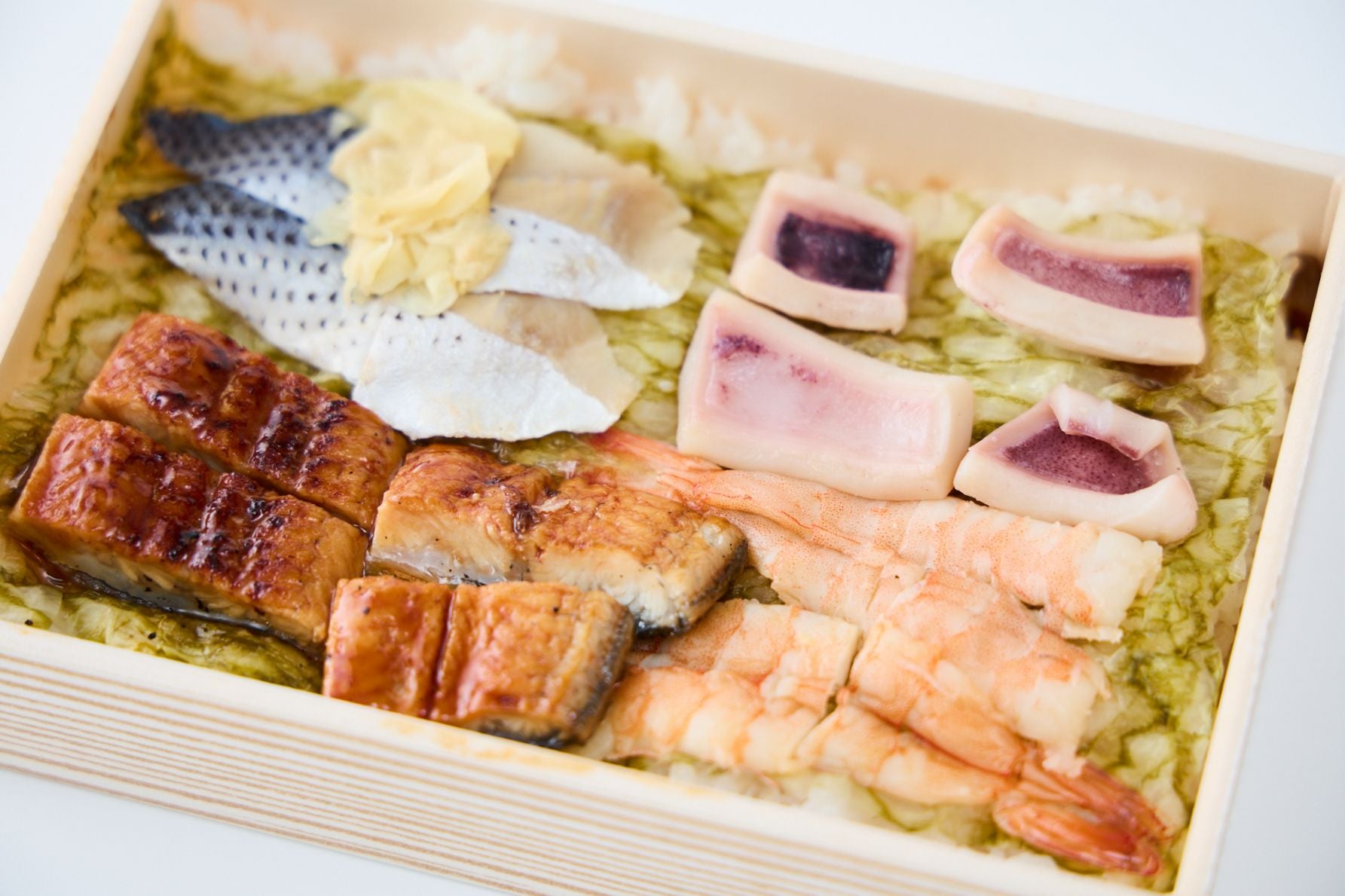 厚焼き玉子をめくると現れる、蒸しえび、いかの一夜干し、うなぎ、こはだといった具沢山な「えび千両ちらし」