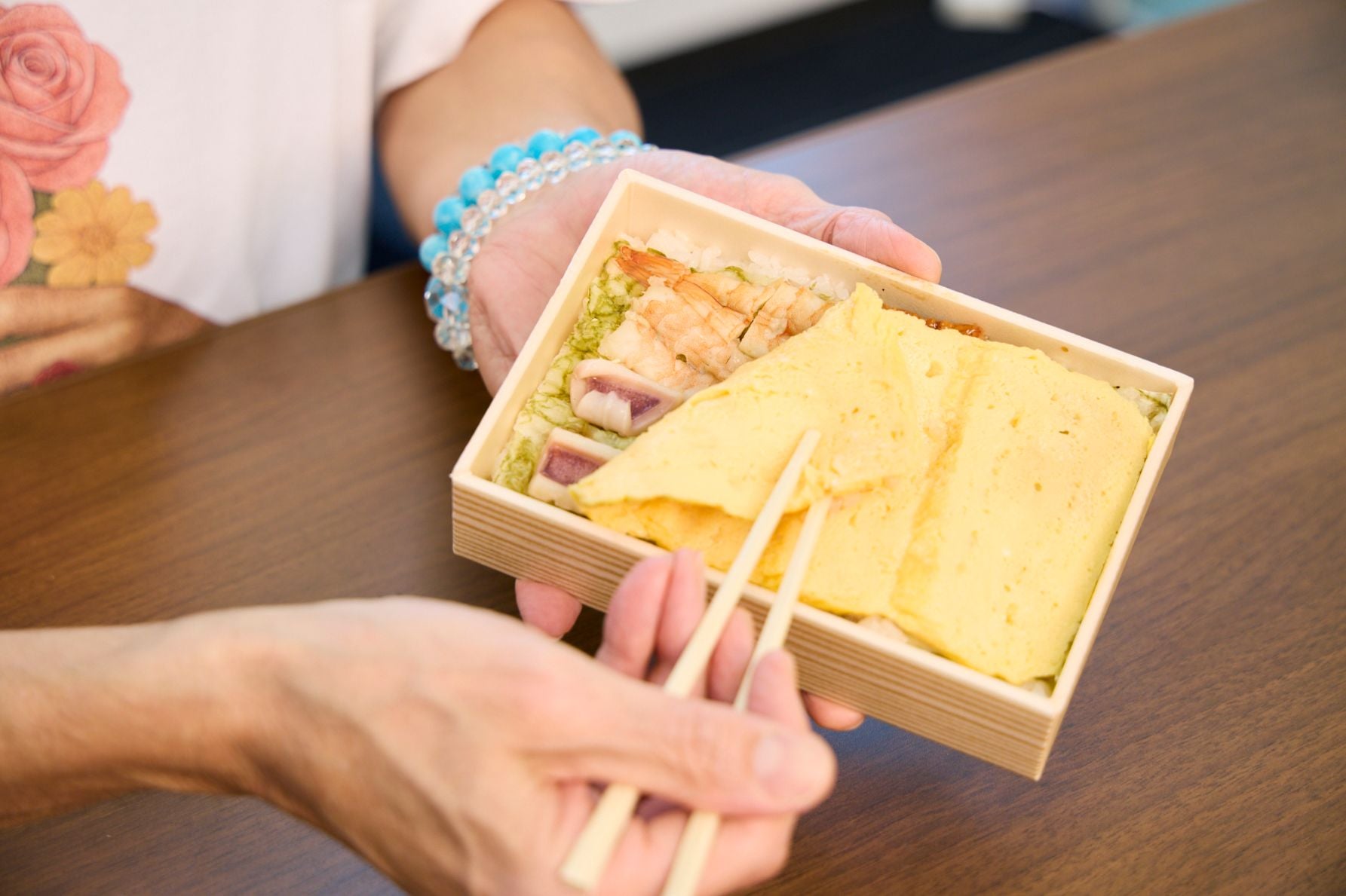 東京駅で人気の個性派駅弁「えび千両ちらし」。一見玉子焼きだけだが、めくると海鮮（えび、うなぎ、いか、こはだ）が隠れている