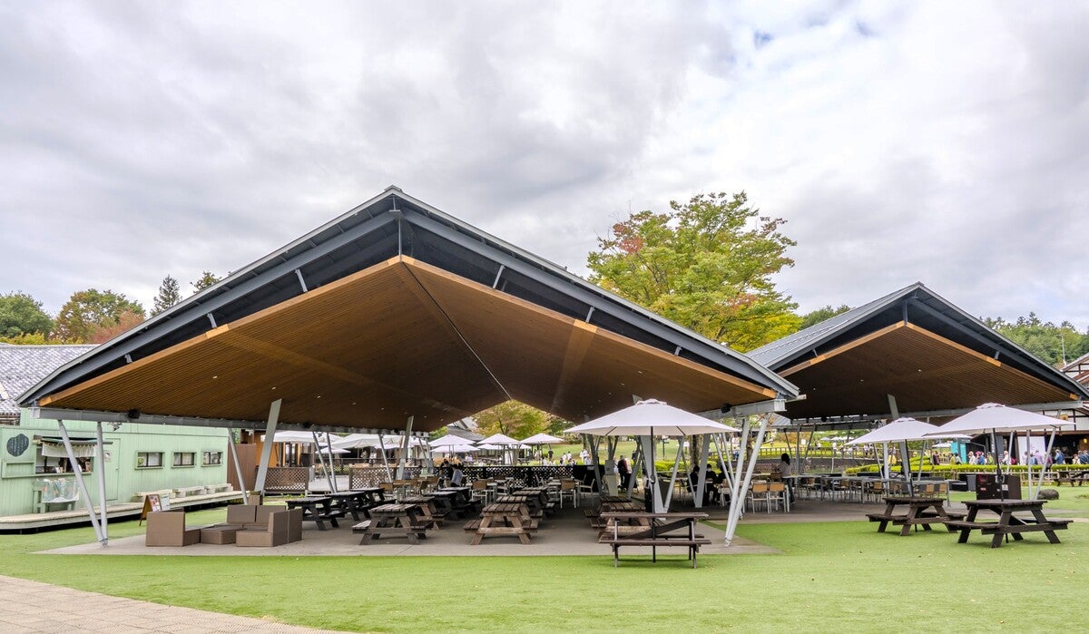 リゾート風のソファとテーブル、木製ベンチ＆テーブルが並ぶ飲食コーナー