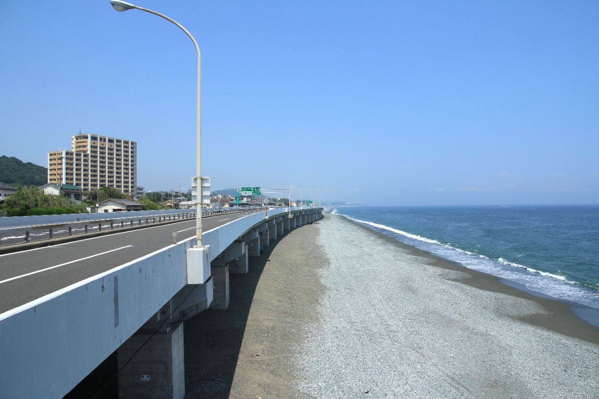 西湘バイパスの高架道路と白砂の海岸、青空に映えるシーサイドビュー