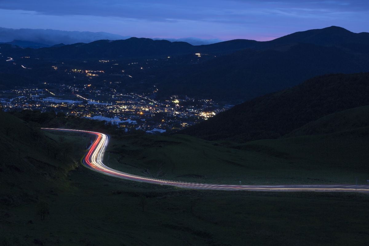 夜景に浮かぶ由布の街と県道11号のライトトレイル