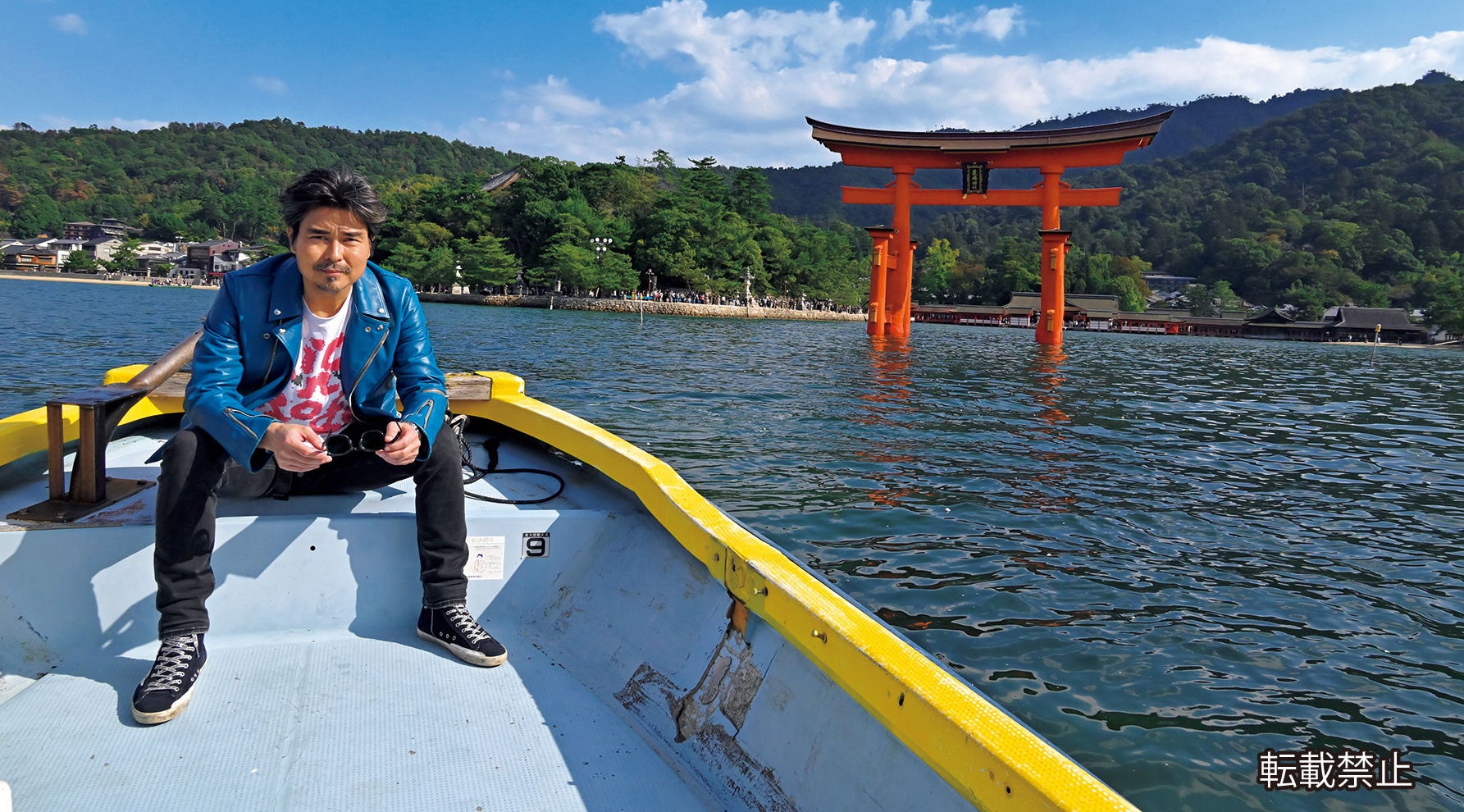 宮島の厳島神社を背景に船にのる小澤征悦氏
