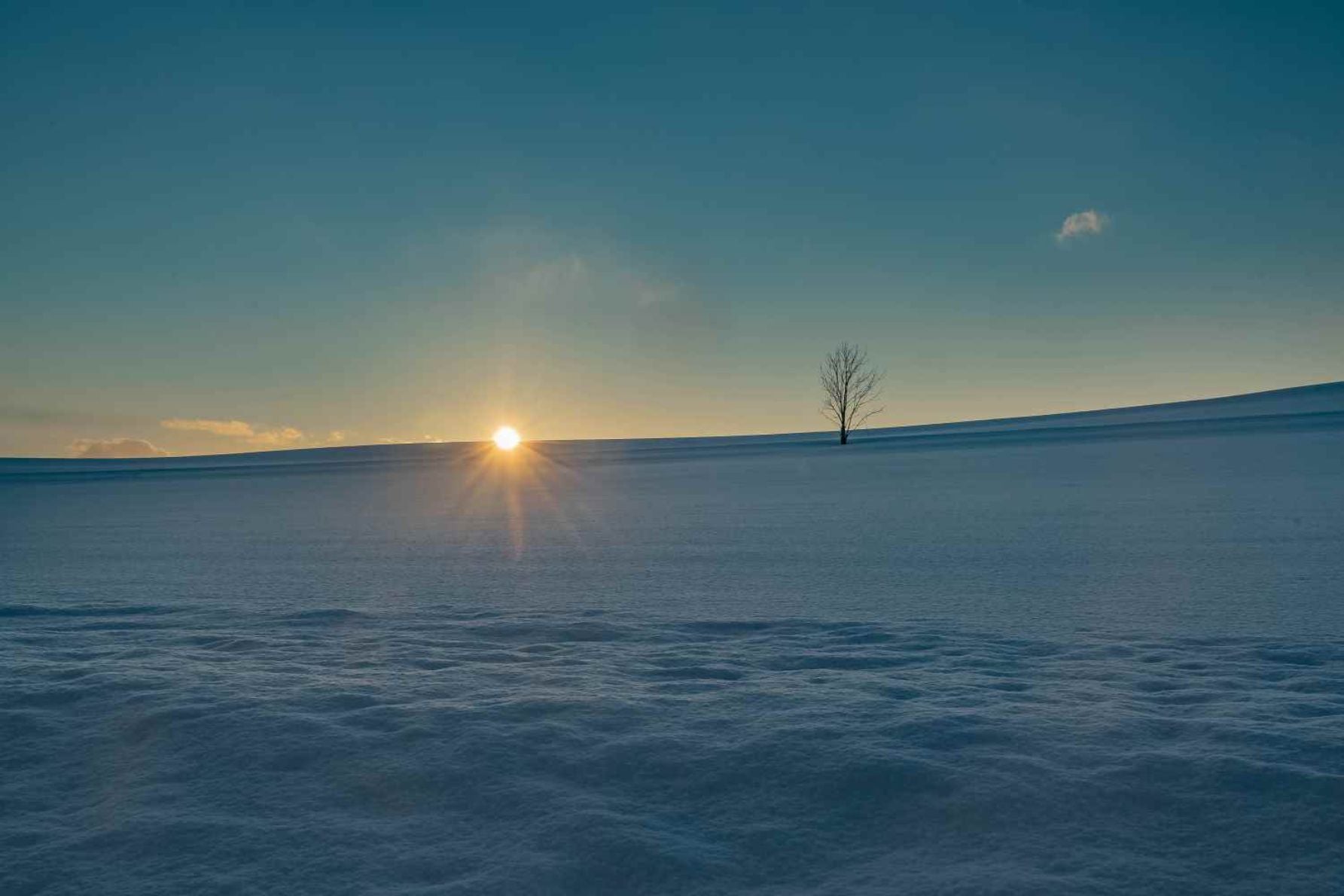 雪原に夕日が沈む