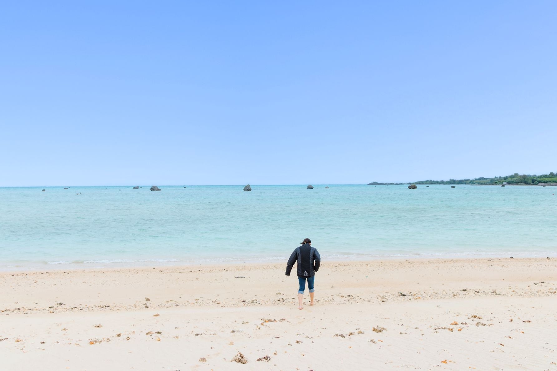 日本の渚100選「佐和田の浜」。遠浅の海に津波で運ばれた巨岩が点在する光景