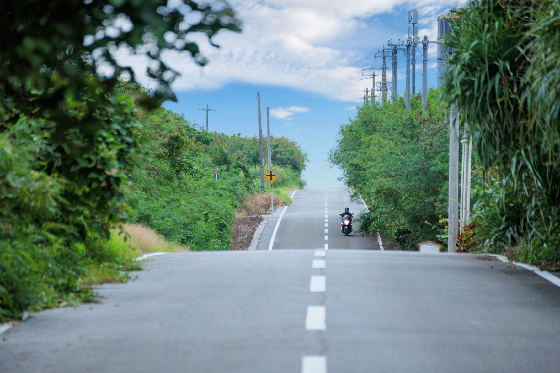 来間島・長間浜へと続く一本道。木々に囲まれた隠れ家ビーチへの入り口
