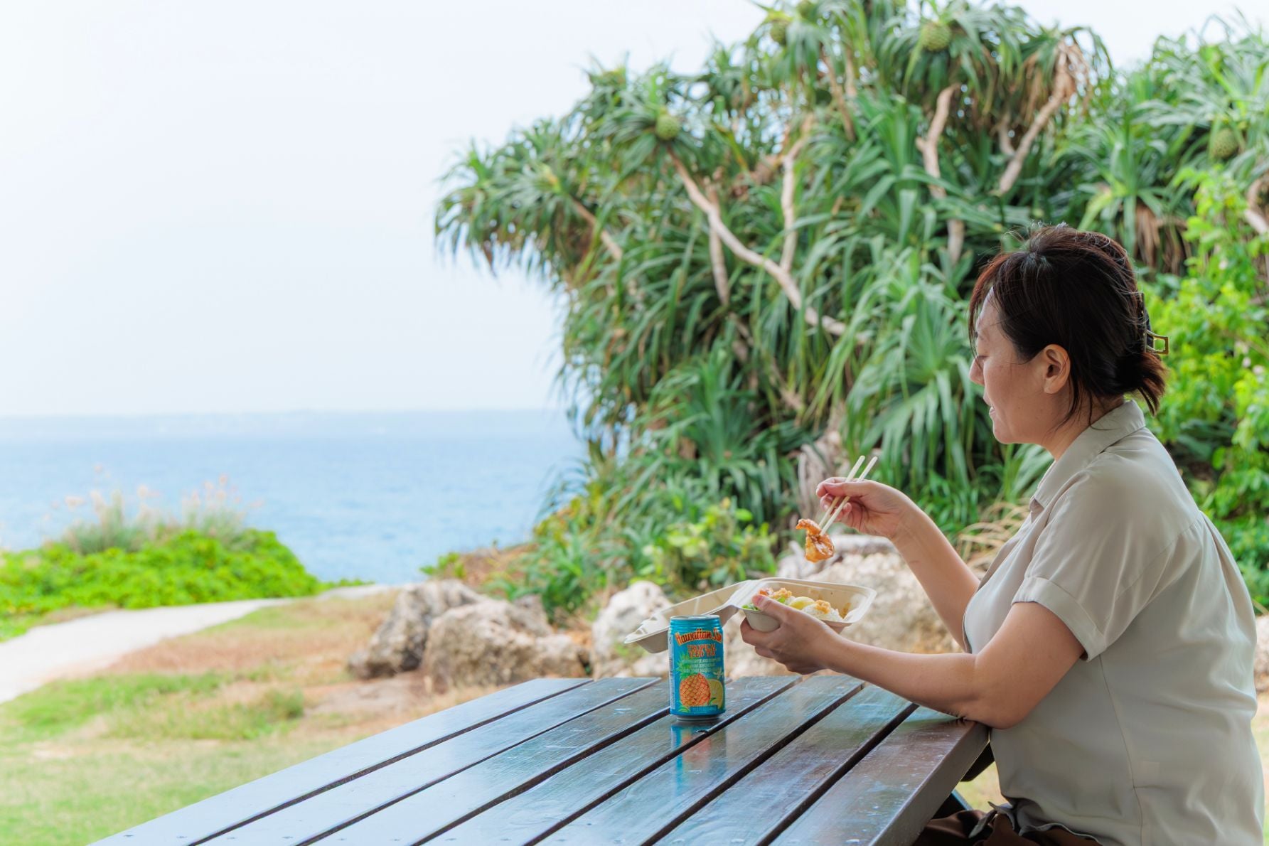 宮古島の青い海を眺めながら、HARRY'Sのテラス席で食事を楽しむ様子