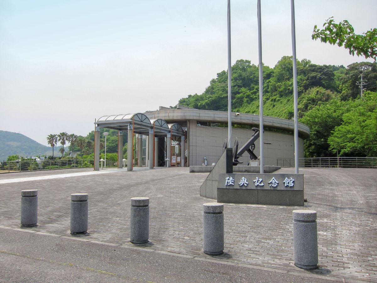 周防大島にある陸奥記念館の外観。緑に囲まれたエントランスと記念碑が並ぶ広場。