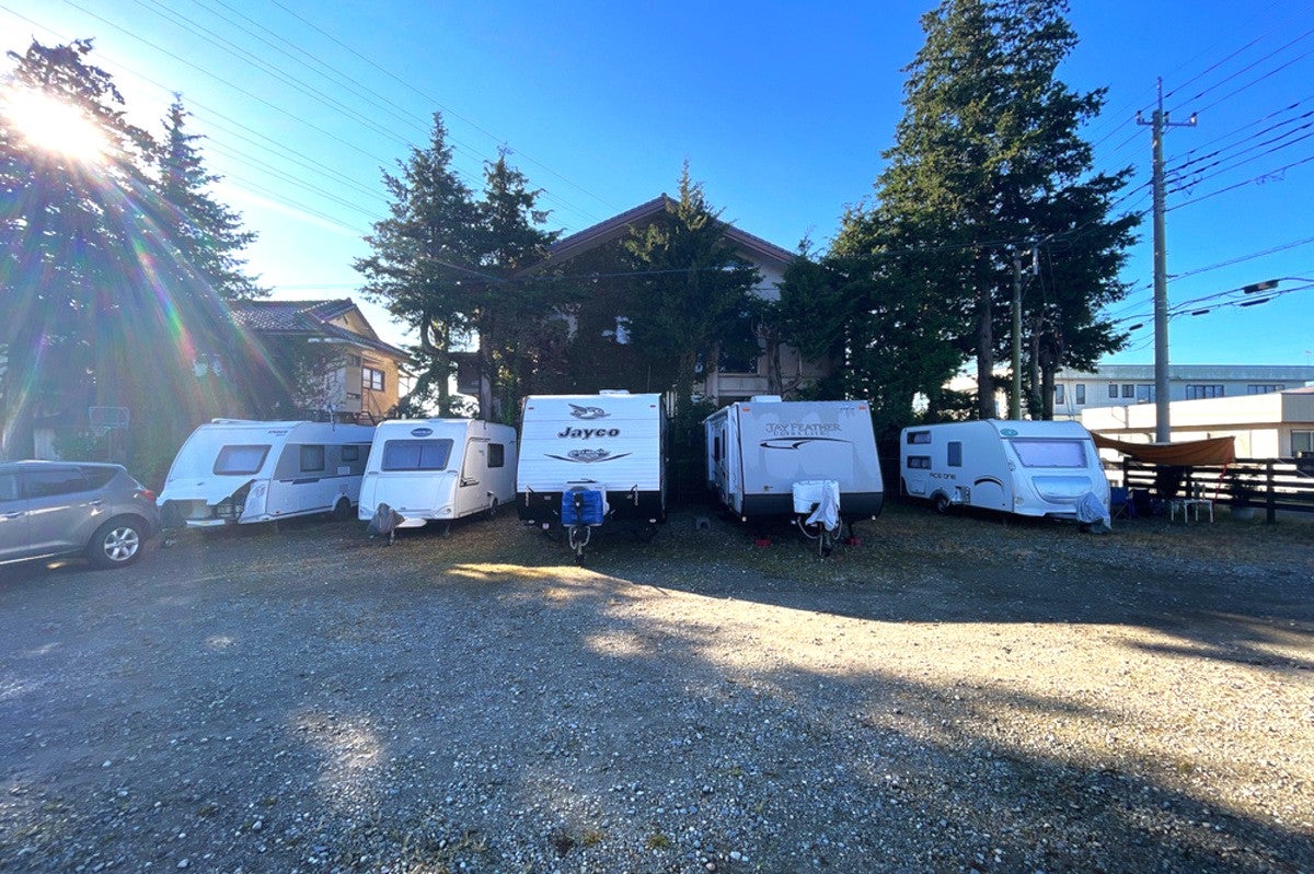 砂利の駐車場に並べられた5台のキャンピングトレーラー