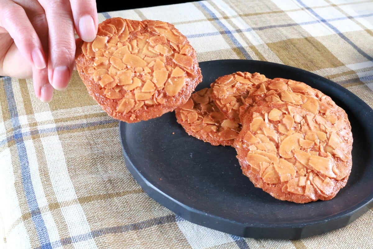 皿に載せたクッキーと手に1枚持ったクッキー