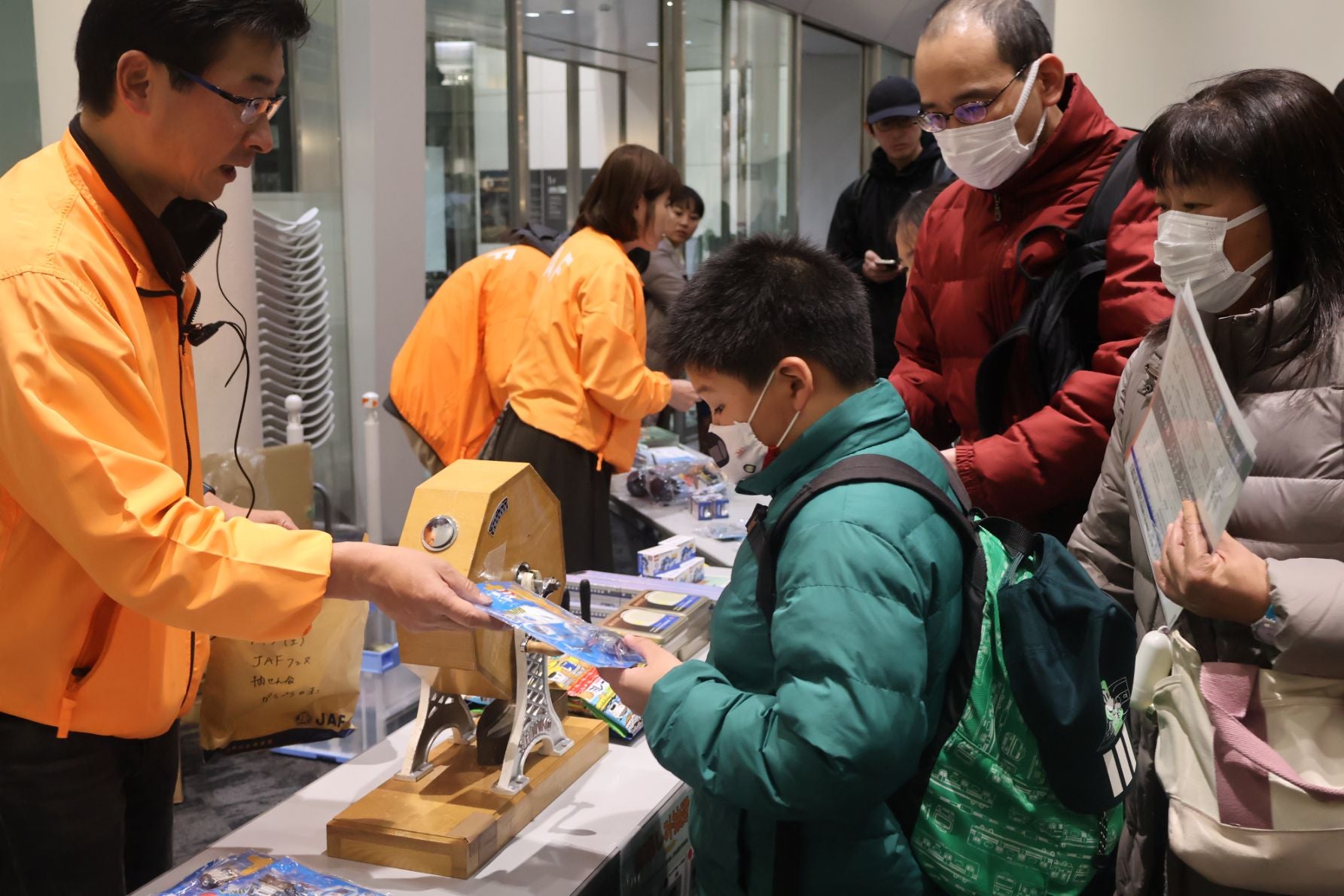 【抽選会の盛り上がり】 特設ステージで当選番号が読み上げられ、歓喜の声を上げる参加者と笑顔で景品を渡すJAFスタッフ。