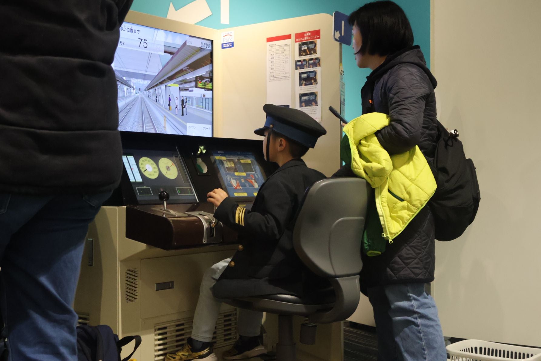 【運転シミュレータ体験】 本物の運転台を模したシミュレータで、真剣な表情でブレーキレバーを操作する子どもの横顔。