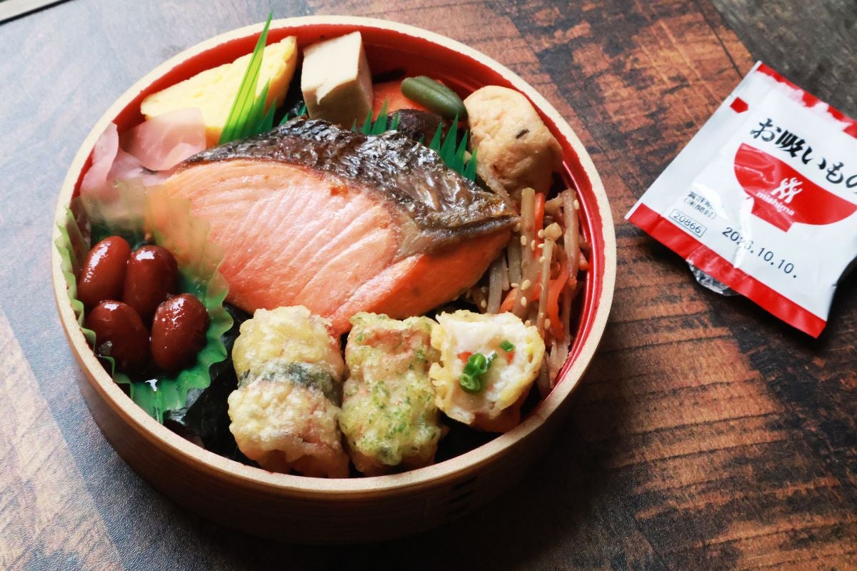 丸い容器に入ったのり弁とお吸い物パッケージの写真