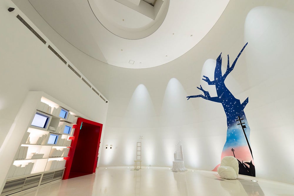 白い「賢治の椅子」が並ぶファンタジックホールと壁面に映る映像演出